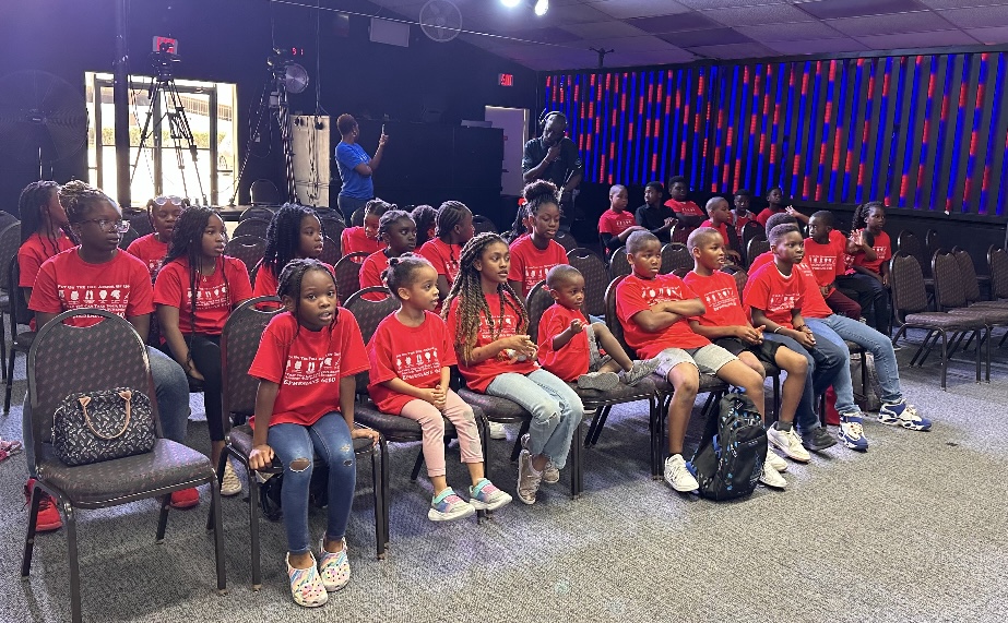 Children in Red Shirts Seated Together at the OFM Houston Church